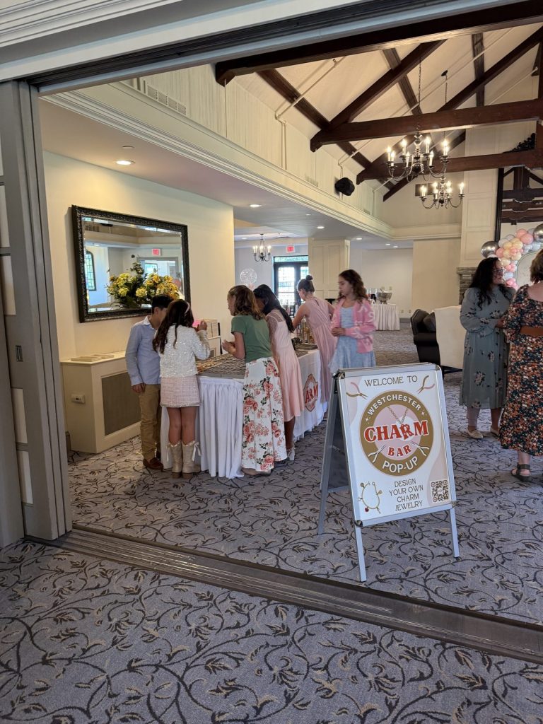 The Mobile Charm Bar welcome sign at a party venue