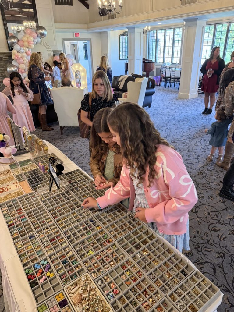 Kids gathered around the Charm Bar at a party in a ballroom