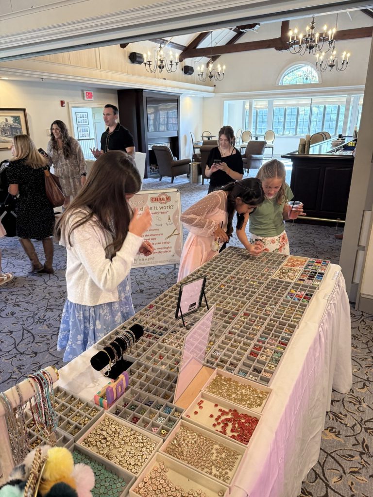 Guests browsing the charm trays at a party in a ballroom