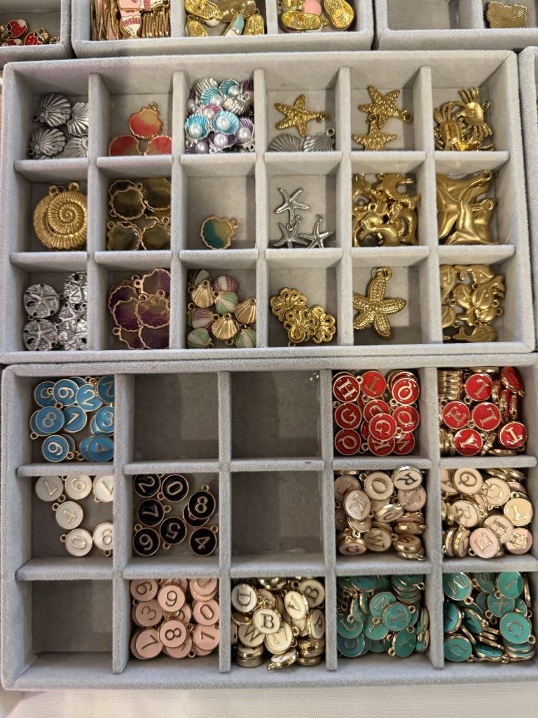 Trays of initial, starfish and shell charms