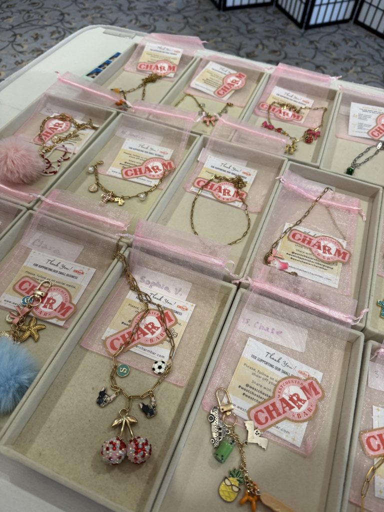 Finished bracelets in Charm Bar gift boxes, lined up for guests at an event