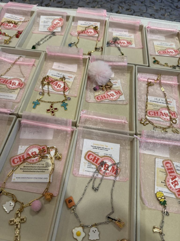 Charm bracelets and keychains boxed for guests at a party