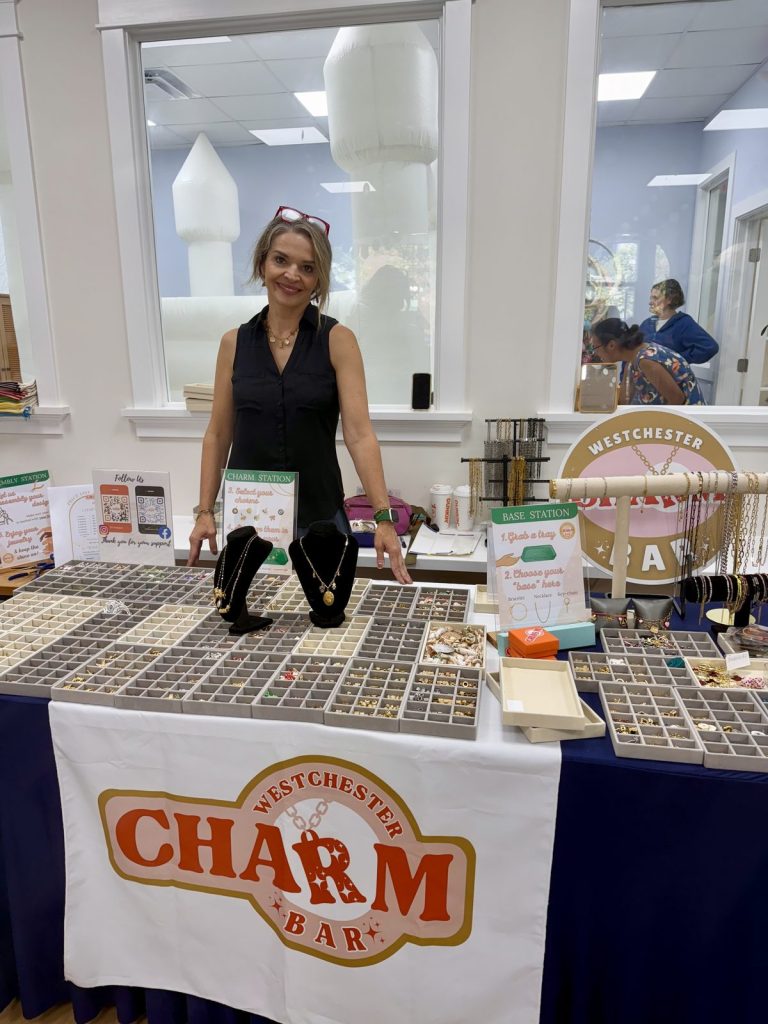 A Charm Bar host at a Mobile Charm Bar table with the Westchester Charm Bar tablecloth