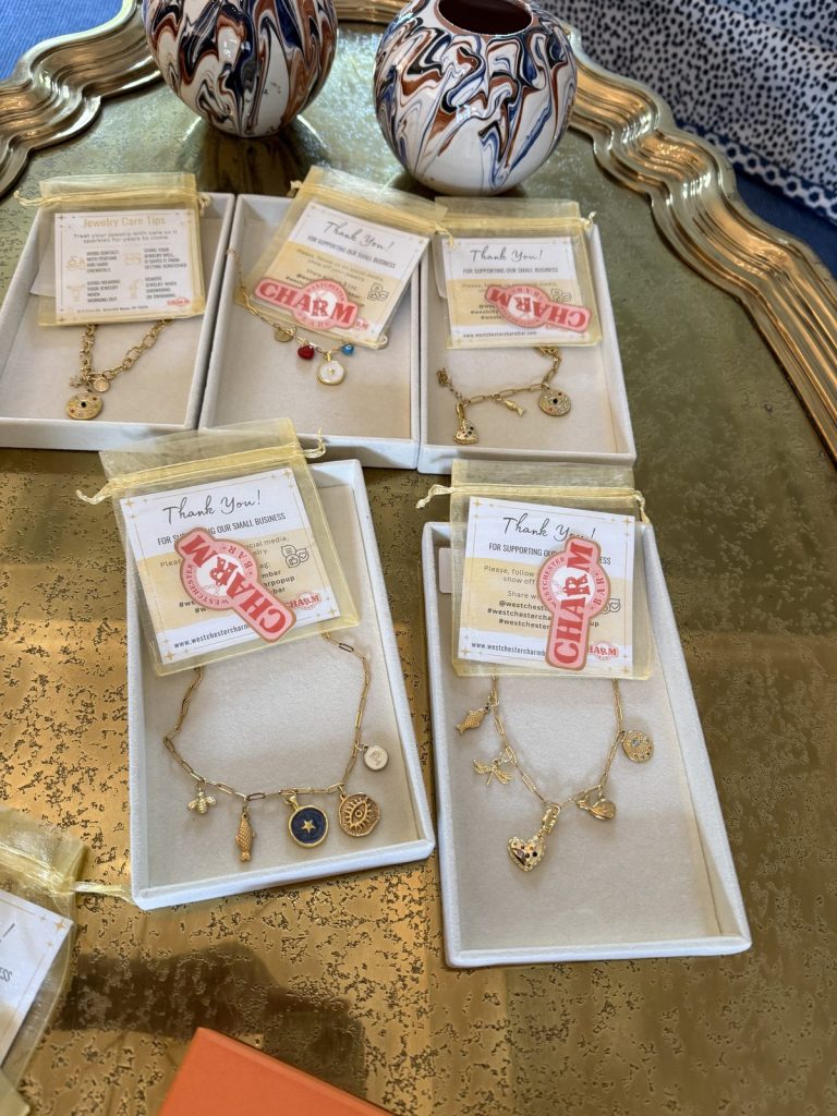 Finished charm jewelry in gift boxes with Westchester Charm Bar pouches at a private event