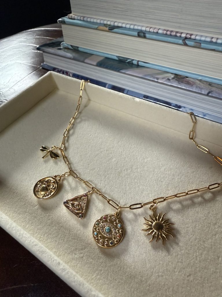Paperclip chain necklace with a sun, an evil eye medallion and a triangle charm