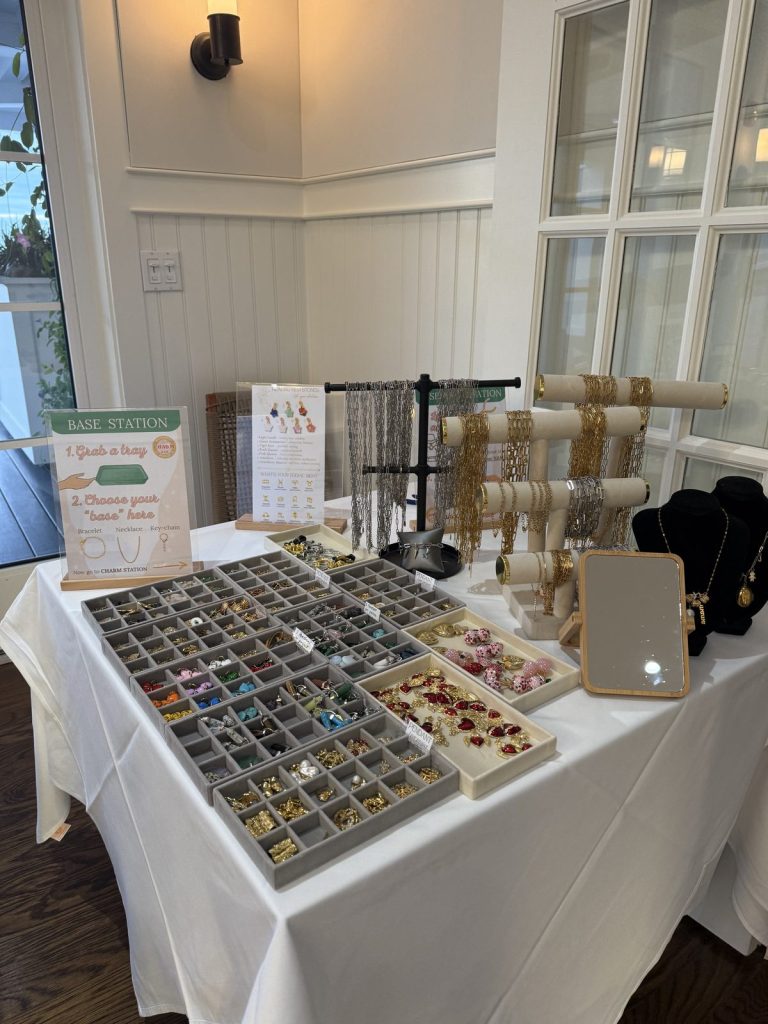 The base station with bracelets and necklaces next to the charm trays