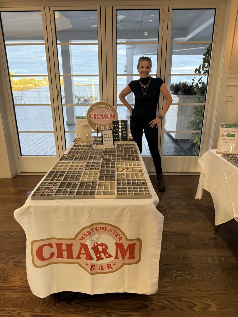 A Charm Bar host beside the table at a waterfront venue