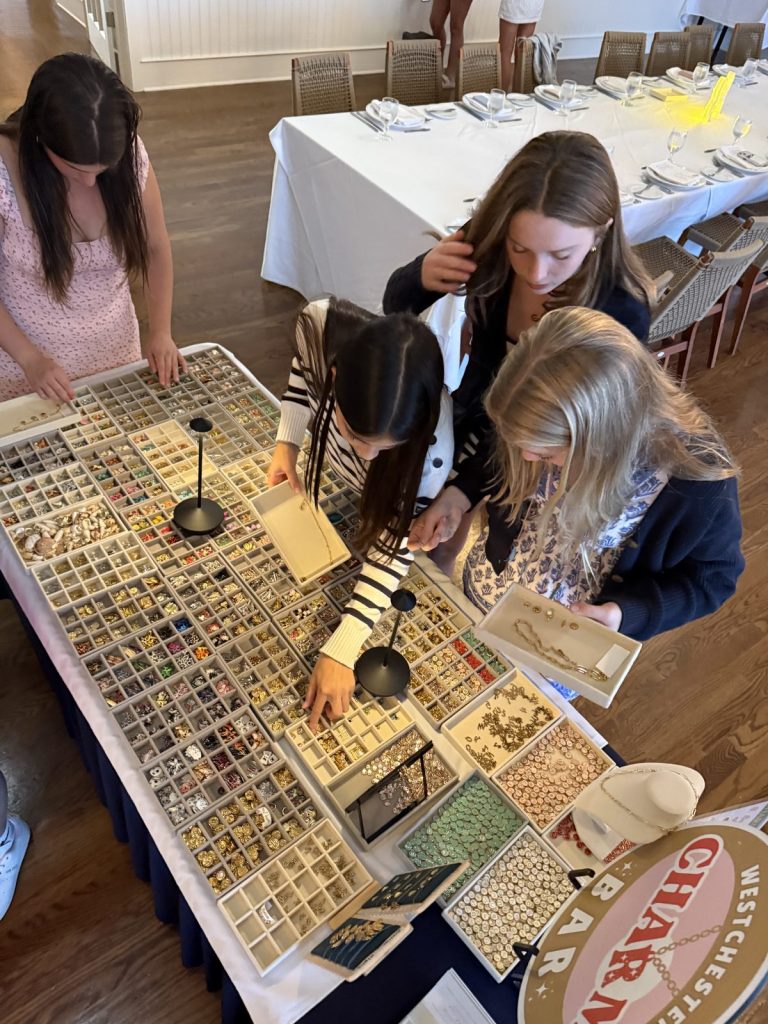 Teens choosing charms at a Mobile Charm Bar table