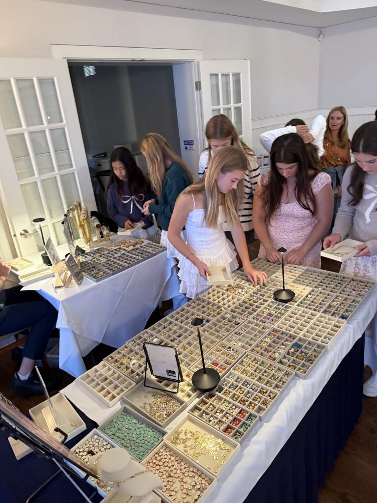 Teens gathered around the Charm Bar table at a party