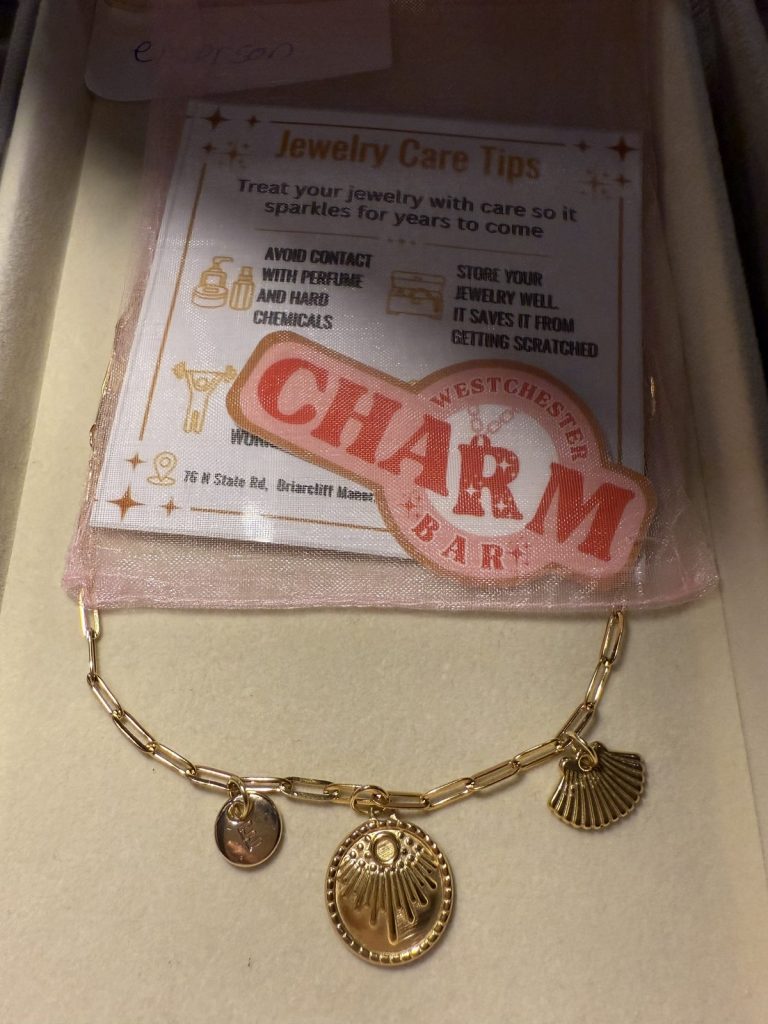 Necklace with a shell, a sun medallion and an initial charm