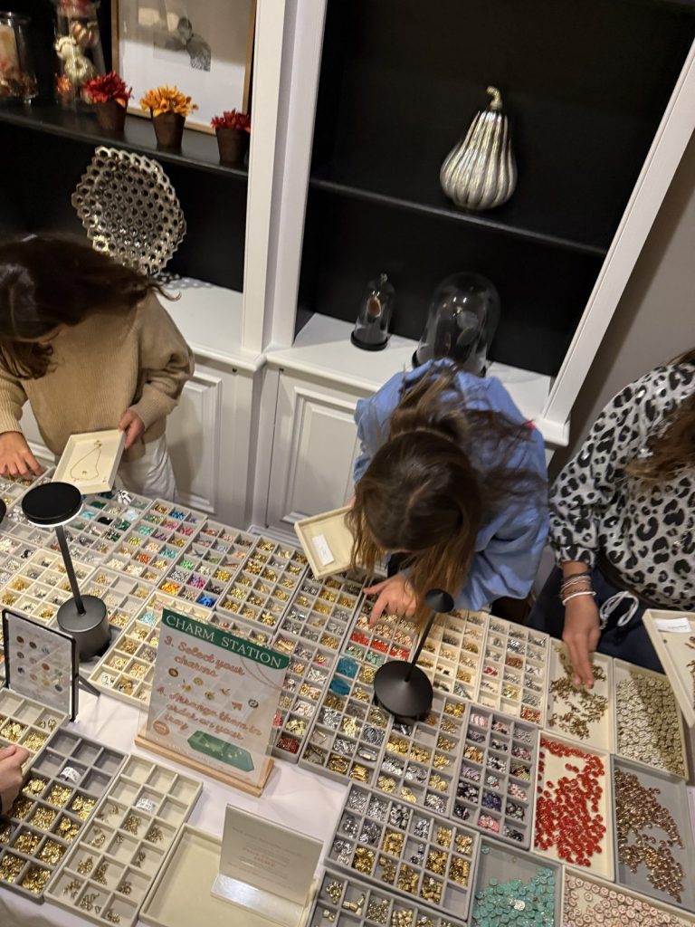 Girls picking bases at the bracelet and necklace display