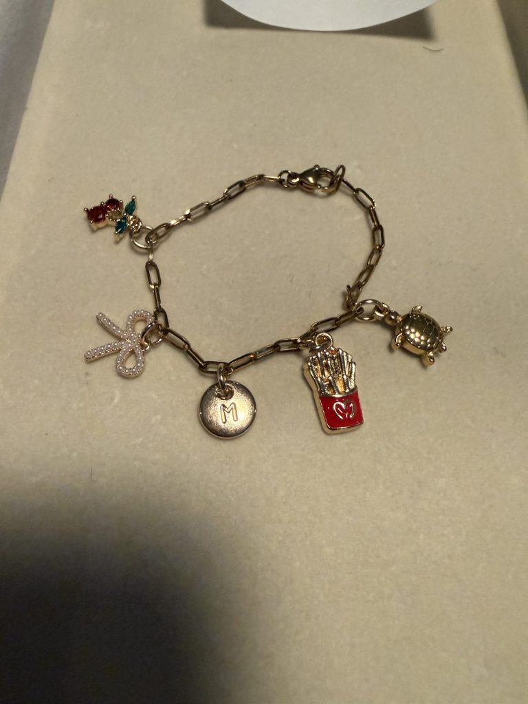 Charm bracelet with a bow, an initial M, fries and a turtle