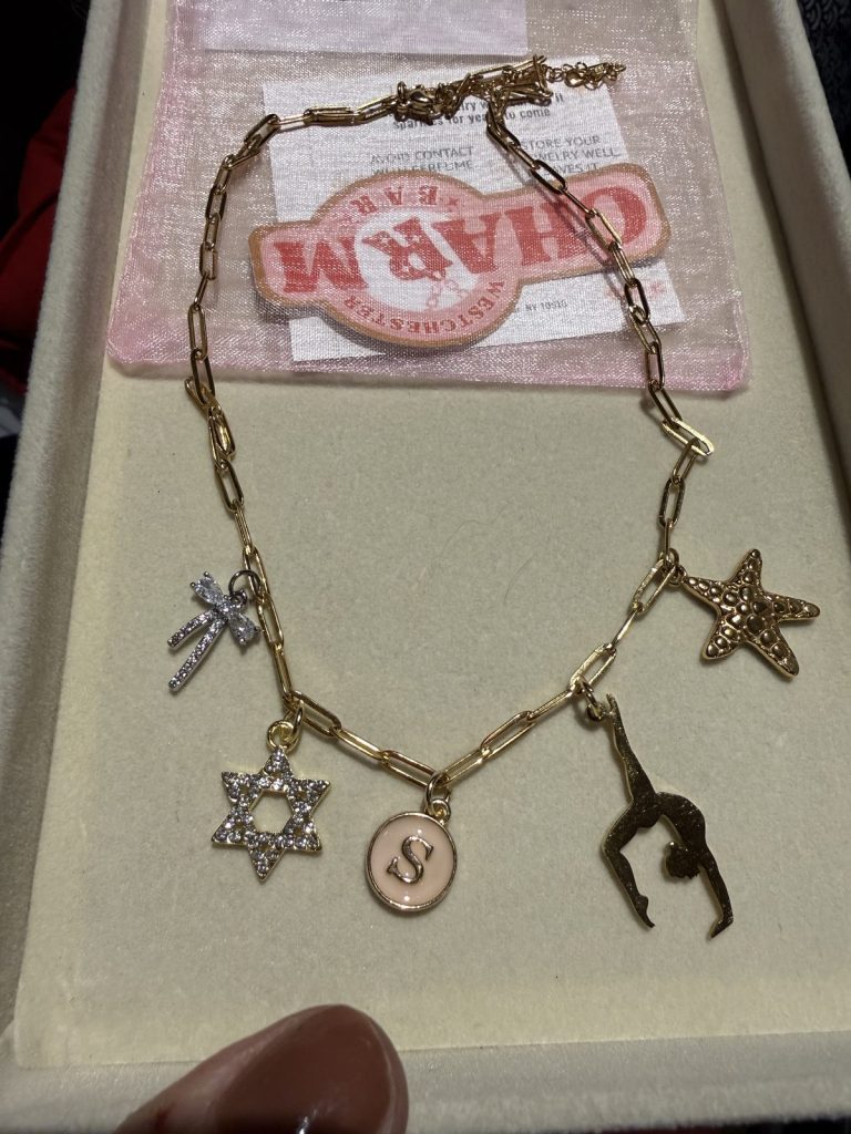 Gold charm necklace with a gymnast, a starfish and an initial S
