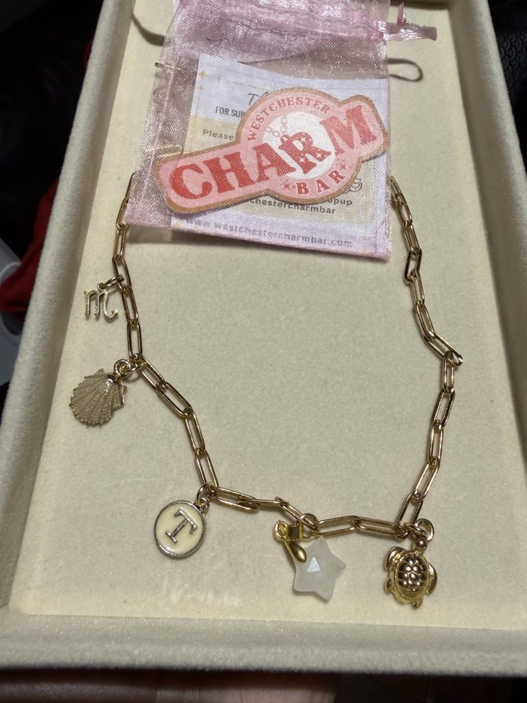 Charm bracelet with a shell, an initial I, a star and a turtle