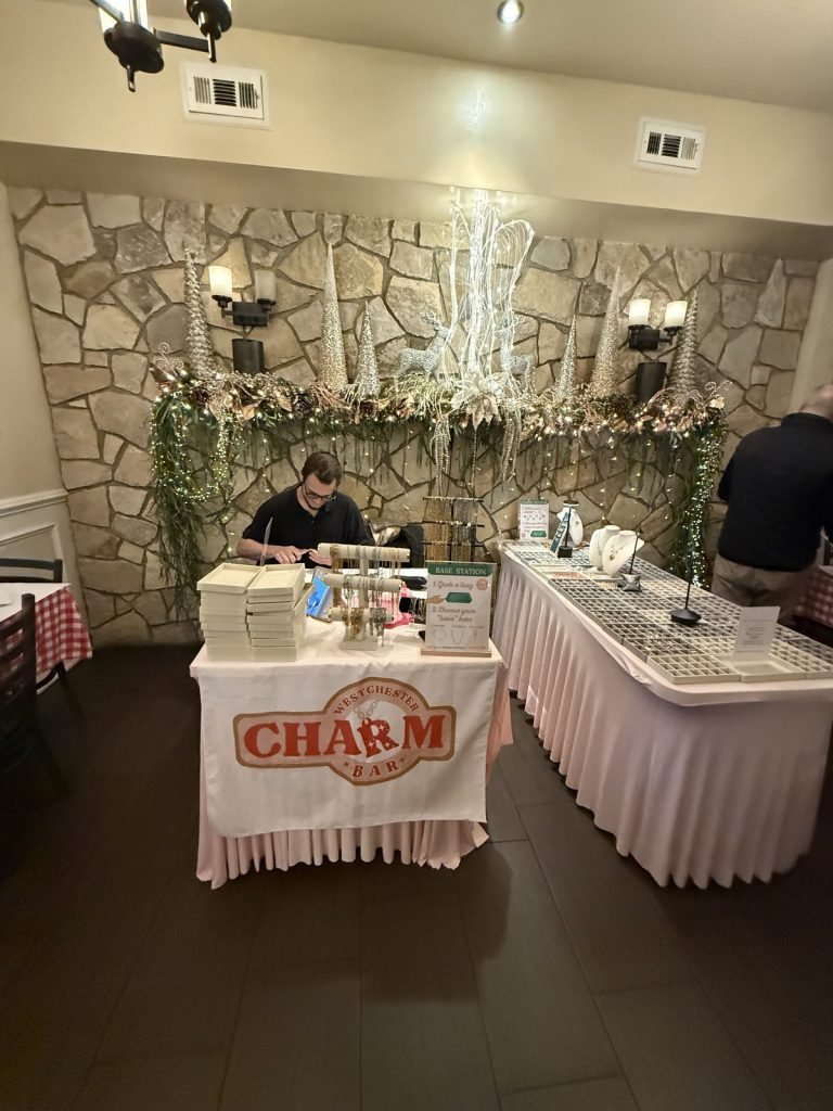 Mobile Charm Bar against a stone wall with flower garlands