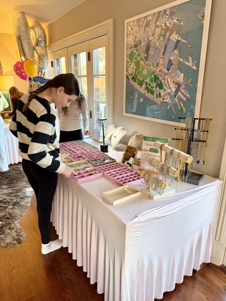 A guest choosing charms at a table set up in a dining room