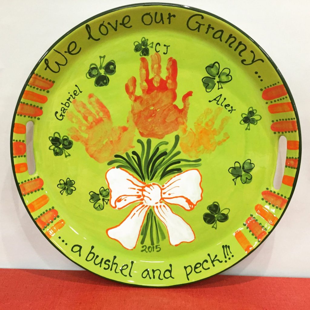 Lime green tray with orange handprint bouquet and shamrocks reading We Love Our Granny
