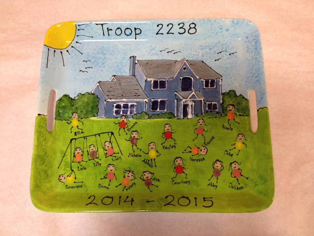 Scout troop tray painted with a house and lawn where fingerprint girls play on swings
