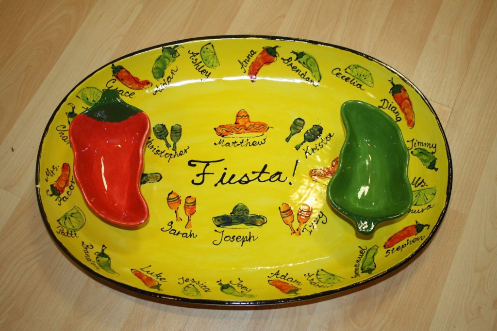 Yellow fiesta oval platter with fingerprint peppers and sombreros, plus two pepper-shaped dip bowls