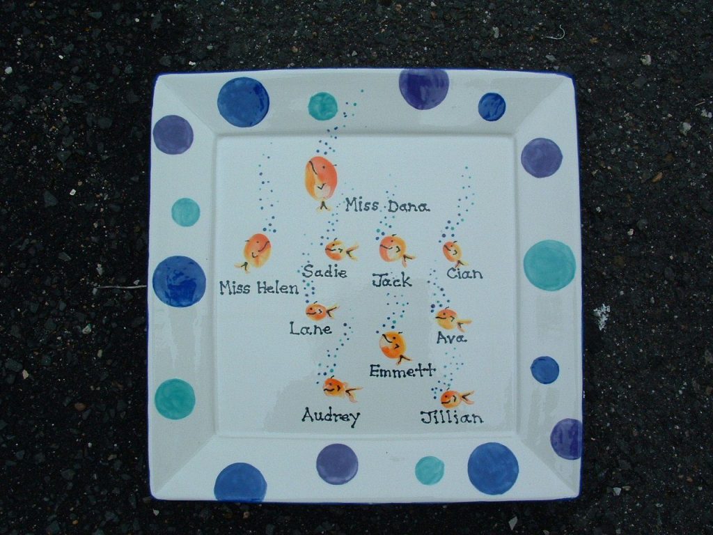 Hand-painted square plate of orange fingerprint goldfish with names and a blue and teal dot border