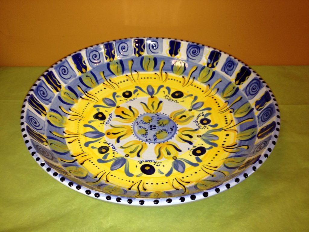 Large shallow bowl in blue and yellow with a bold floral pattern and children's names