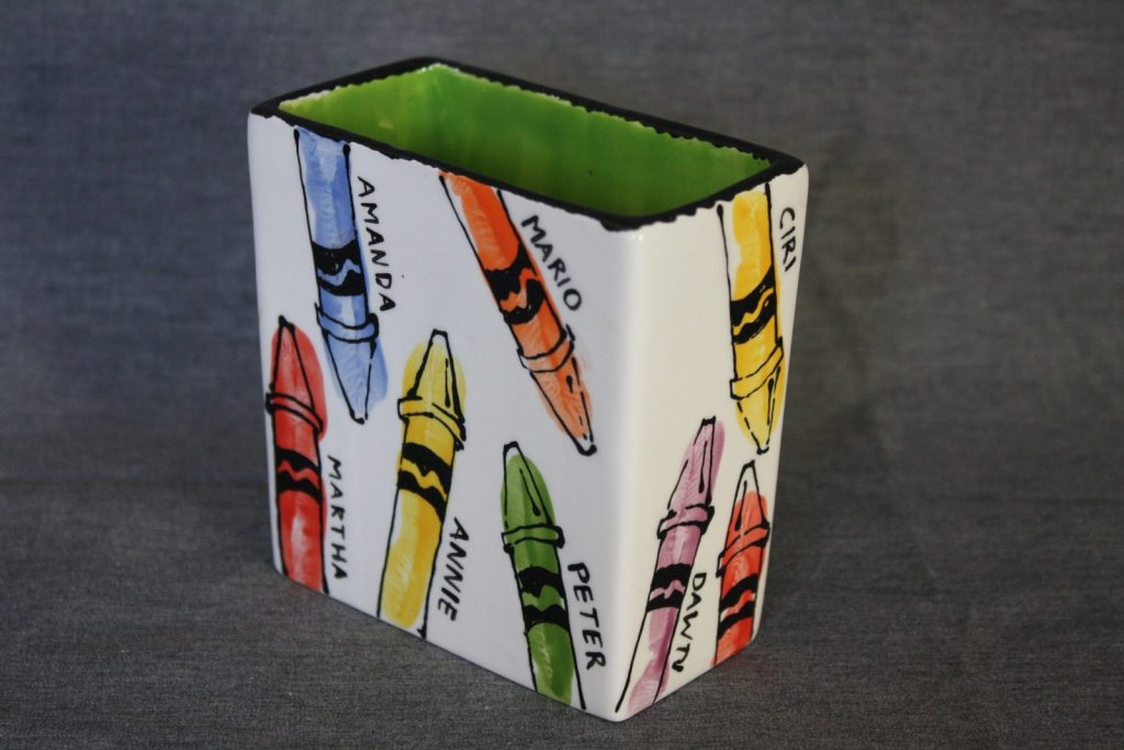 Hand-painted rectangular vase covered in bright crayons, each labeled with a child's name