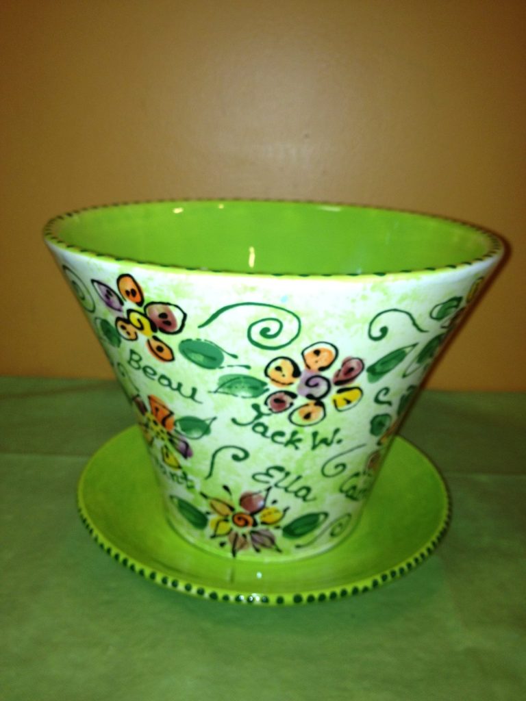 Hand-painted flowerpot and saucer with colorful fingerprint flowers, green swirls and children's names