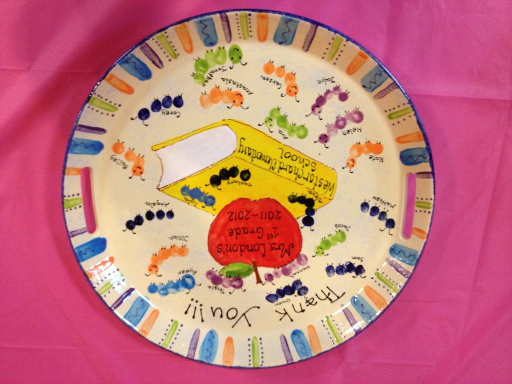Hand-painted round platter with fingerprint caterpillars, a book and an apple saying "Thank you"