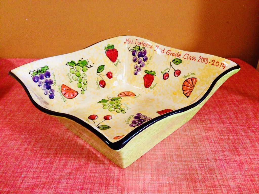 Hand-painted wavy bowl of fingerprint strawberries, grapes and oranges from a 2nd grade class, 2013–2014