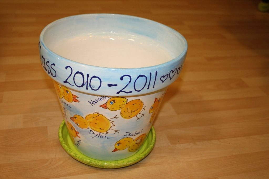 Hand-painted flowerpot and saucer with yellow fingerprint chicks for a 2010–2011 class
