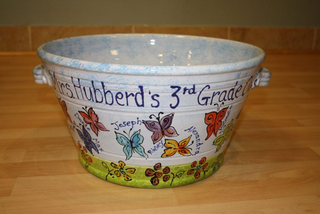 Hand-painted handled bucket from a 3rd grade class with fingerprint butterflies and flowers