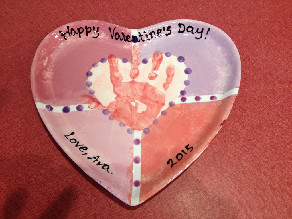 Heart-shaped Valentine's plate with a pink handprint and pastel color-block sections