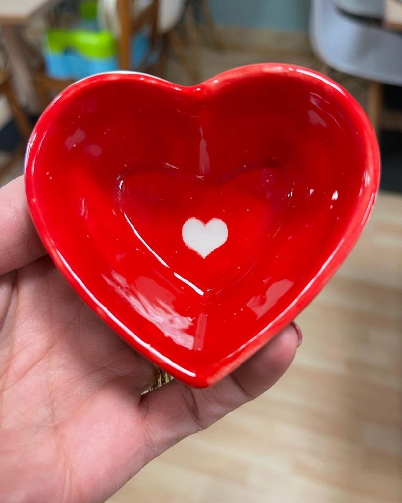 Hand-painted glossy red heart-shaped bowl with a small white heart in the center