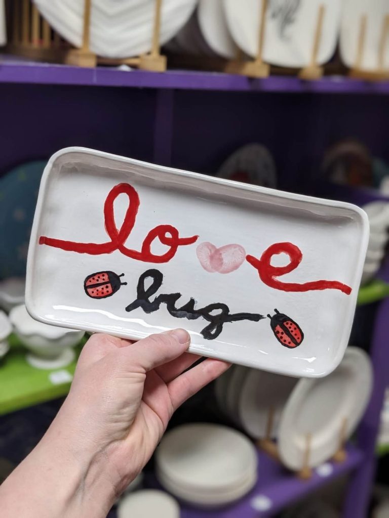 Hand-painted rectangular tray reading love bug in red and black script with ladybugs