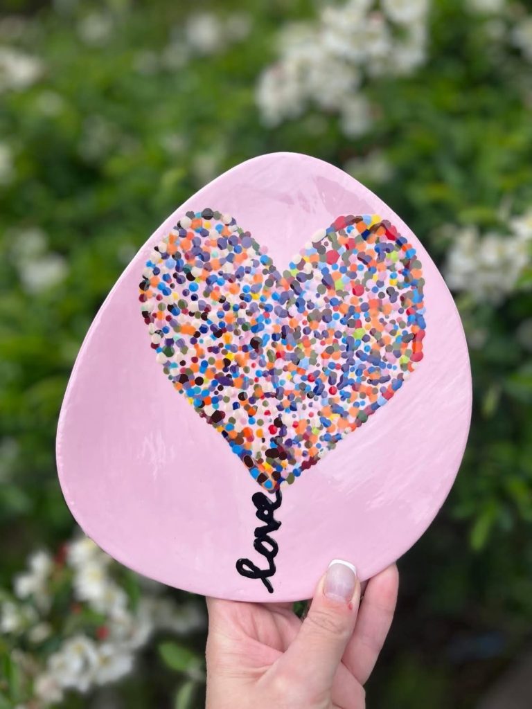 Hand-painted pink dish with a heart of multicolored dots and love written along its stem