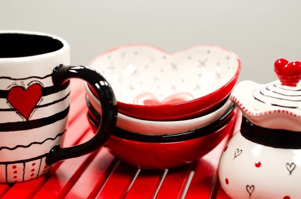 Hand-painted Valentine's table set of a heart mug, stacked heart bowls, and a heart-lidded sugar jar