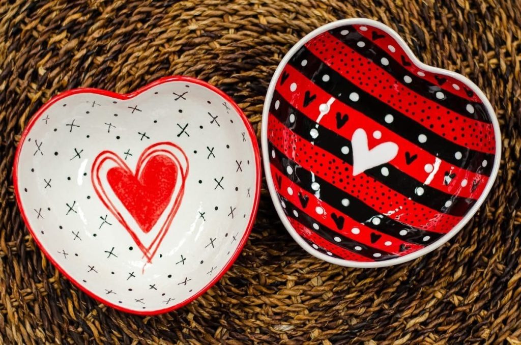 Two hand-painted heart bowls, one white with a red heart and one with red and black stripes